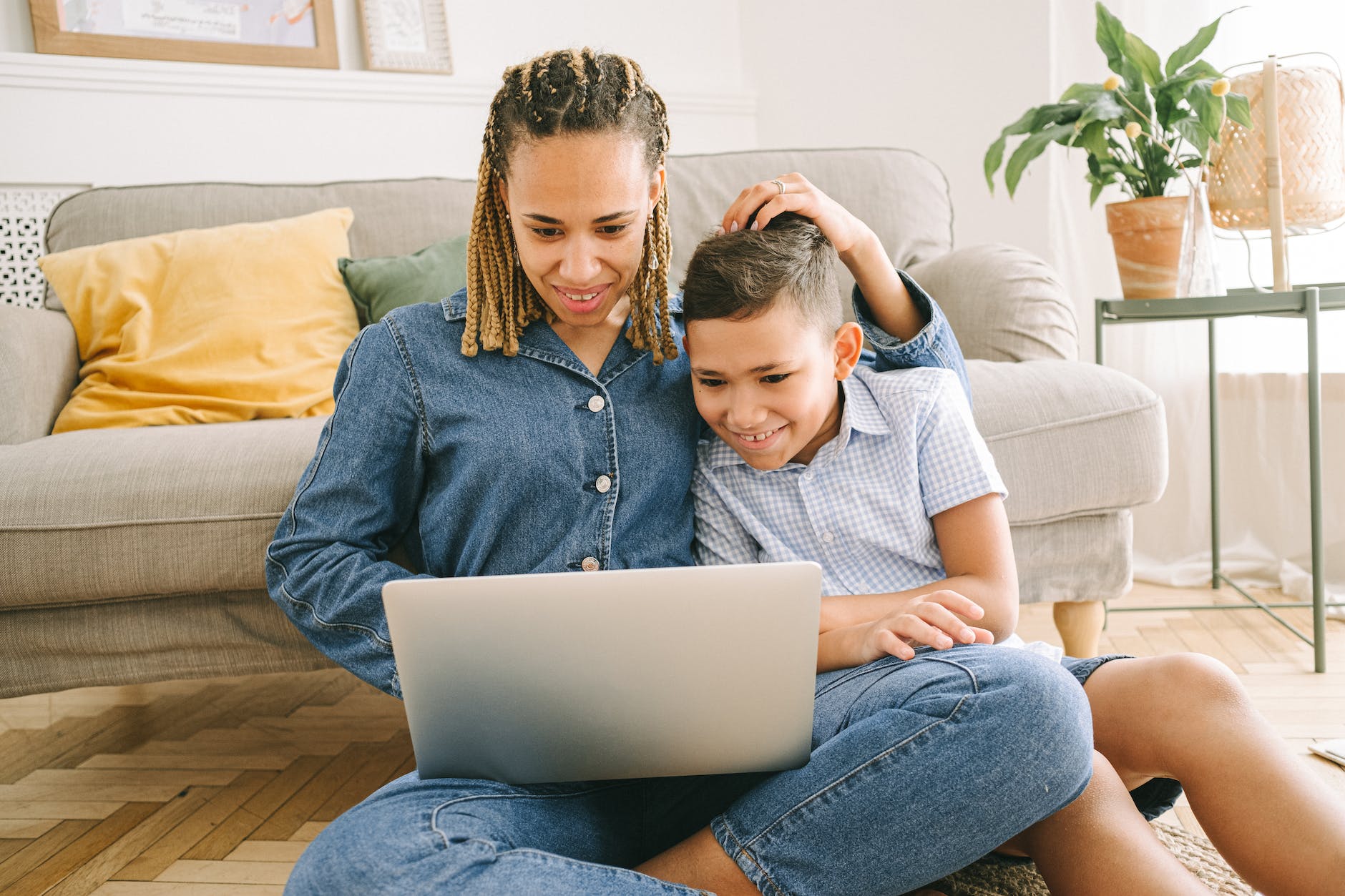 woman and young boy sitting on floor with laptop